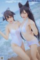 Two young women in bunny ears pose for a picture on the beach.