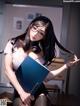 A woman sitting at a desk holding a folder.