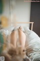 A woman laying on a bed with her back to the camera.