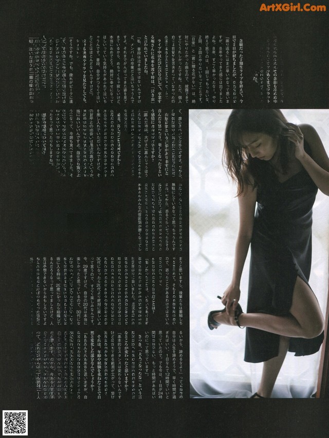 A woman in a black dress standing in front of a window.